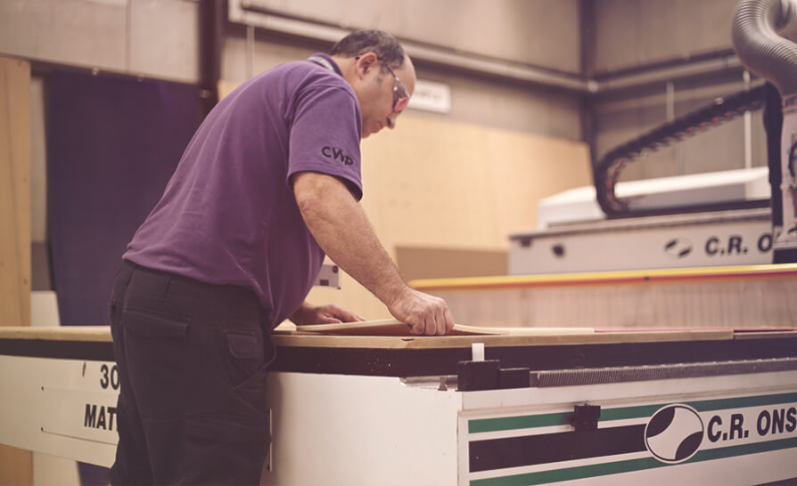 man cutting wood with a machine