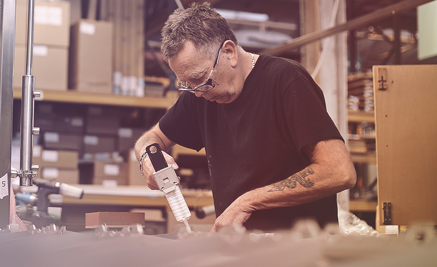 man using a hot-glue gun in a workshop